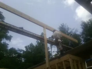 Carpenter setting a ridge beam over a new addition frame — Ice Dam Removal by Roofing Brothers in Terre Haute