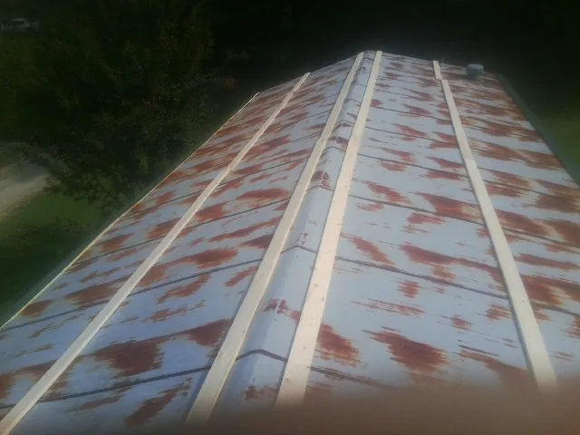 Rusted metal roof panels with new wood purlins before replacement — Storm Damage Roof Repair in Terre Haute by Roofing Brothers
