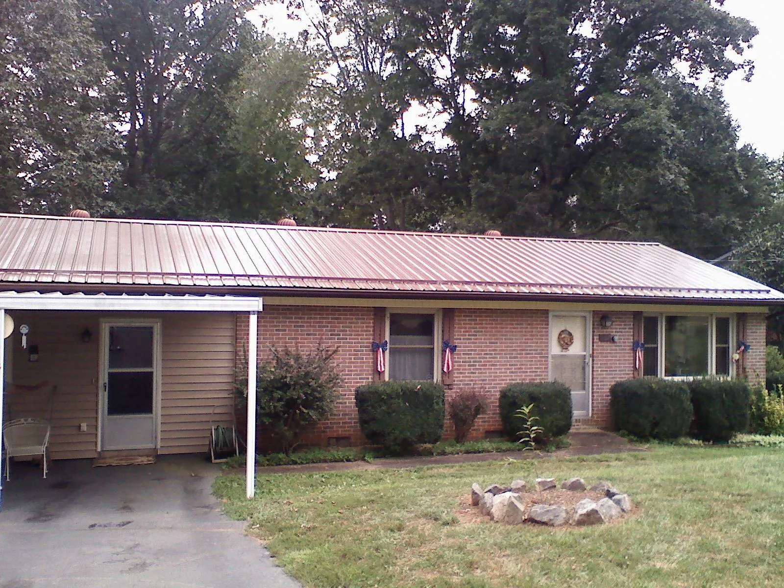 Bronze metal roof and carport on a brick ranch home — Roof Repair work by our crew in Terre Haute